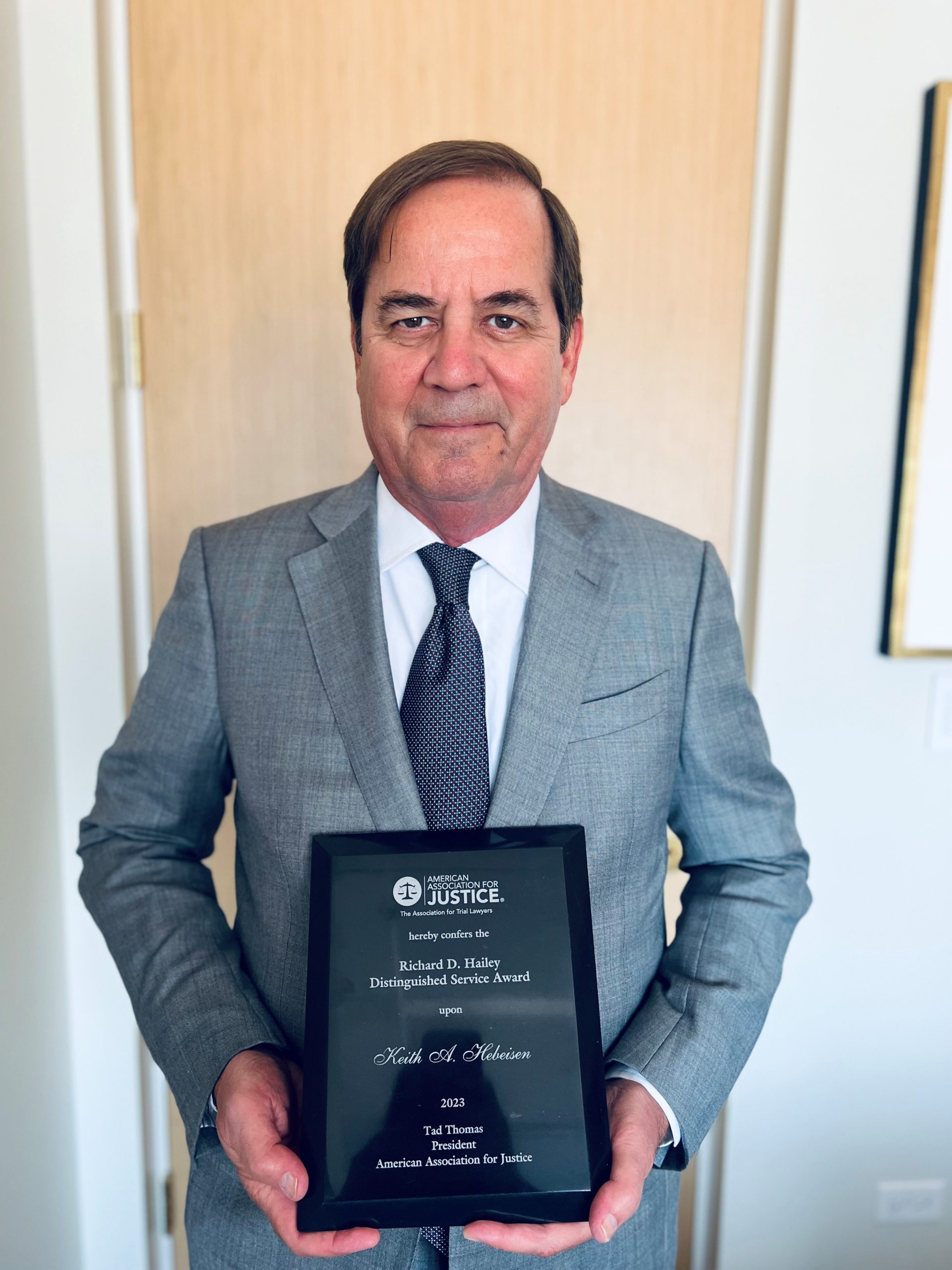 Keith A. Hebeisen holding AAJ award